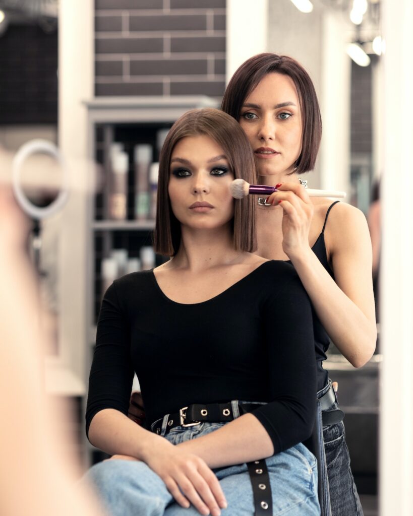make-up artist makes-up in a beauty salon in front of a mirror