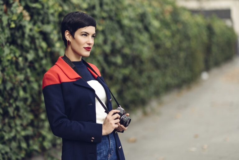 Portrait of fashionable young woman with camera